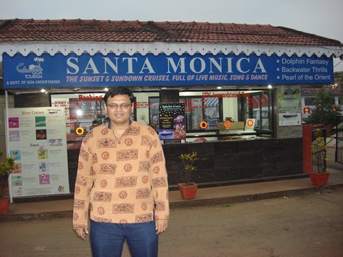 Man in casual clothing standing in front of restaurant.